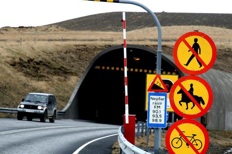 Un cycliste habillé tout en noir est escorté à travers le tunnel par la police