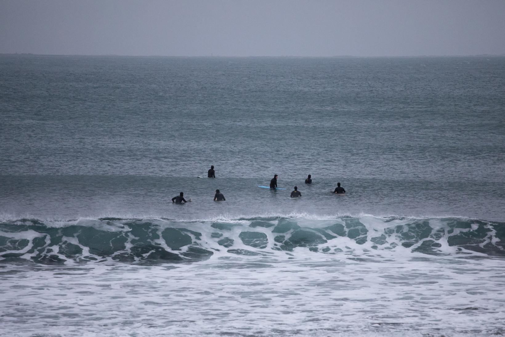 Surfers dans la mer à l'extérieur de Thorlákshöfn en octobre.